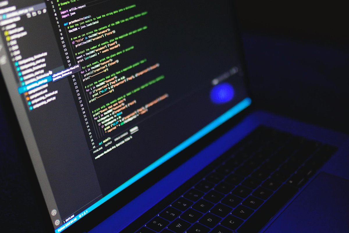 Laptop with code in a dark workspace representing secure credential handling